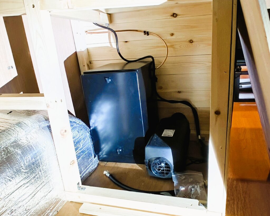 Diesel heater installed inside a campervan conversion with ducting and heating system components