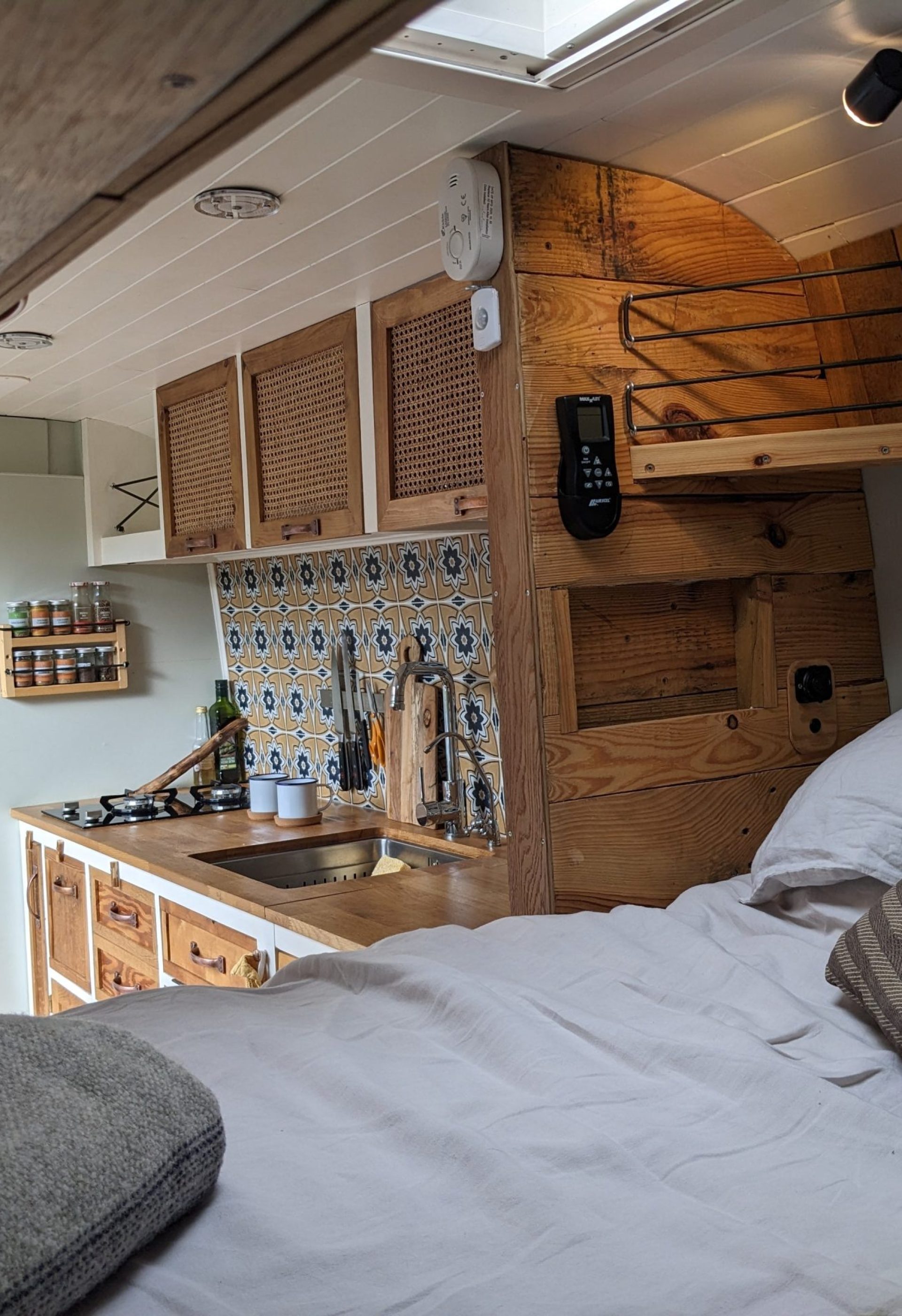 campervan kitchen with hand-built rattan cupboards